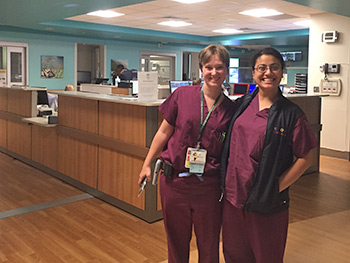 Two residents in scrubs posing during the night shift