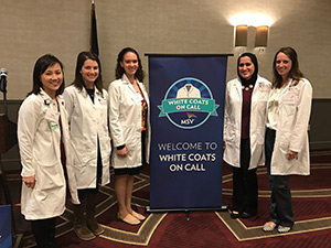 five residents with a banner that says Welcome to White Coats on Call