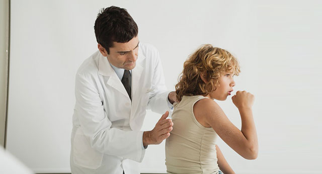 Doctor examining child with cough