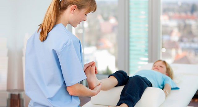 Female healthcare worker examine boy's foot